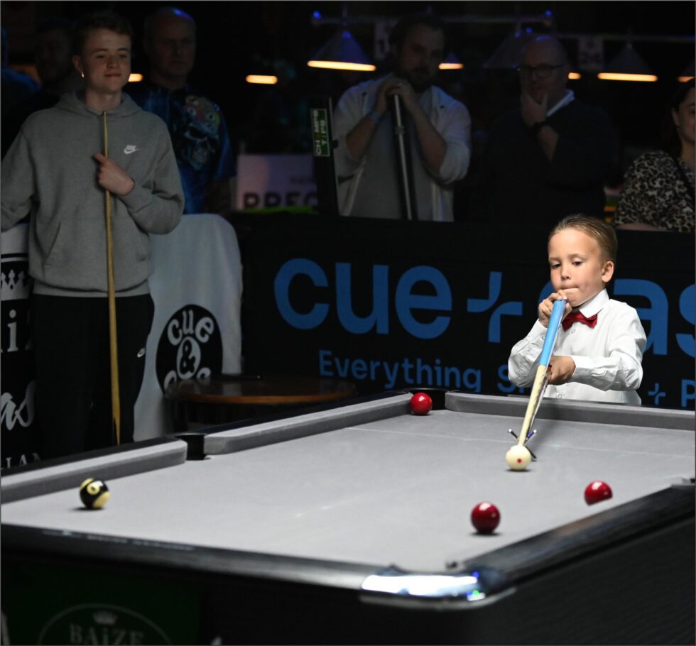 A young player taking a shot on the match table
